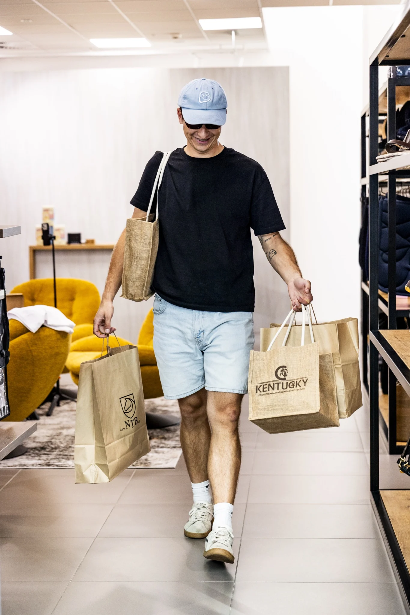 Klient z torbami zakupowymi między regałami showroomu NTB24