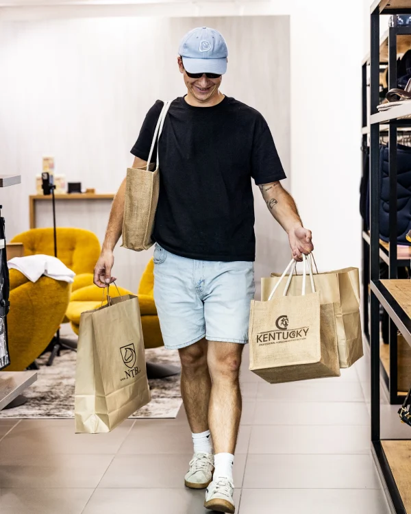 Klient z torbami zakupowymi między regałami showroomu NTB24